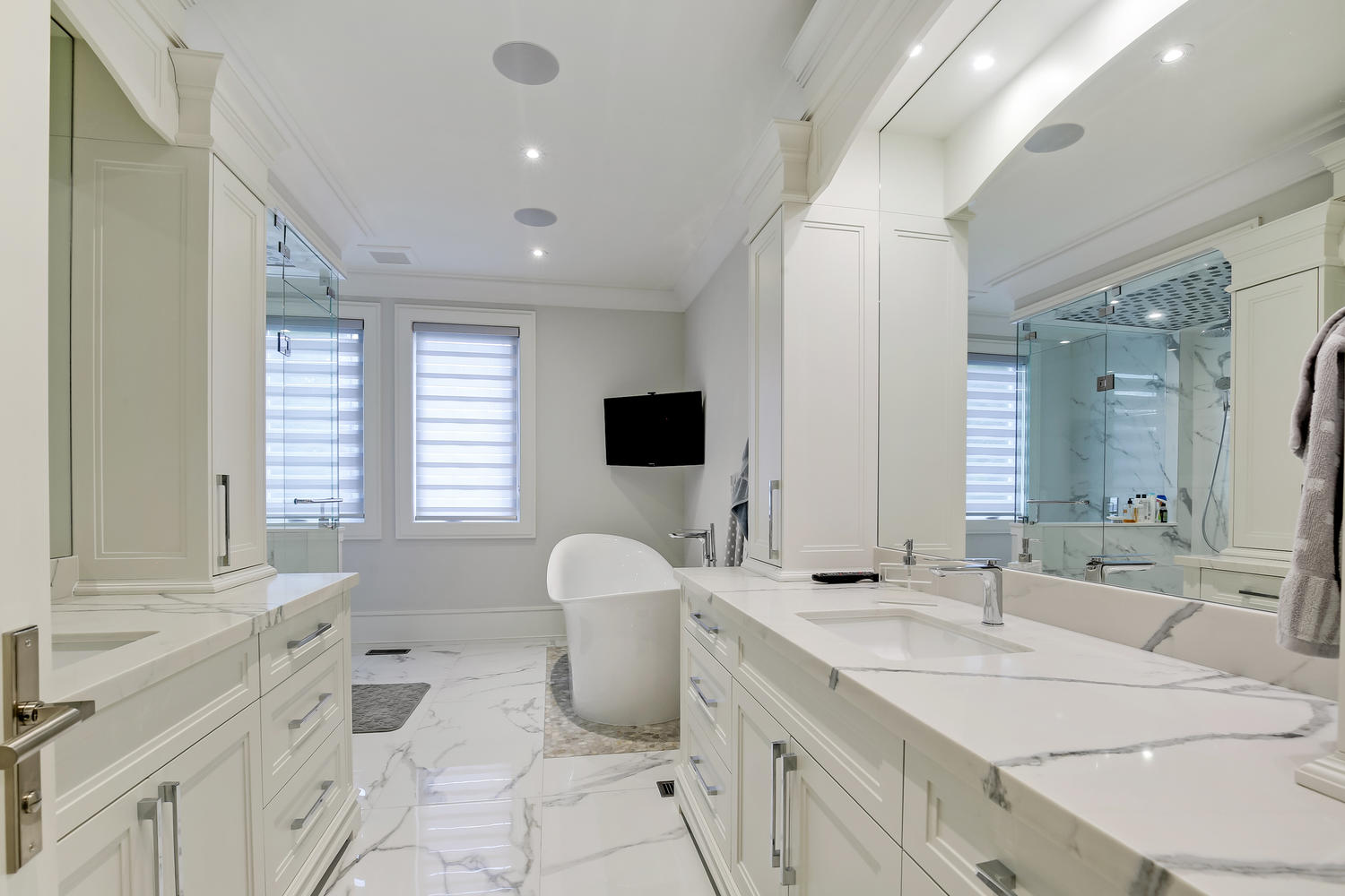 a white themed bathroom with a TV