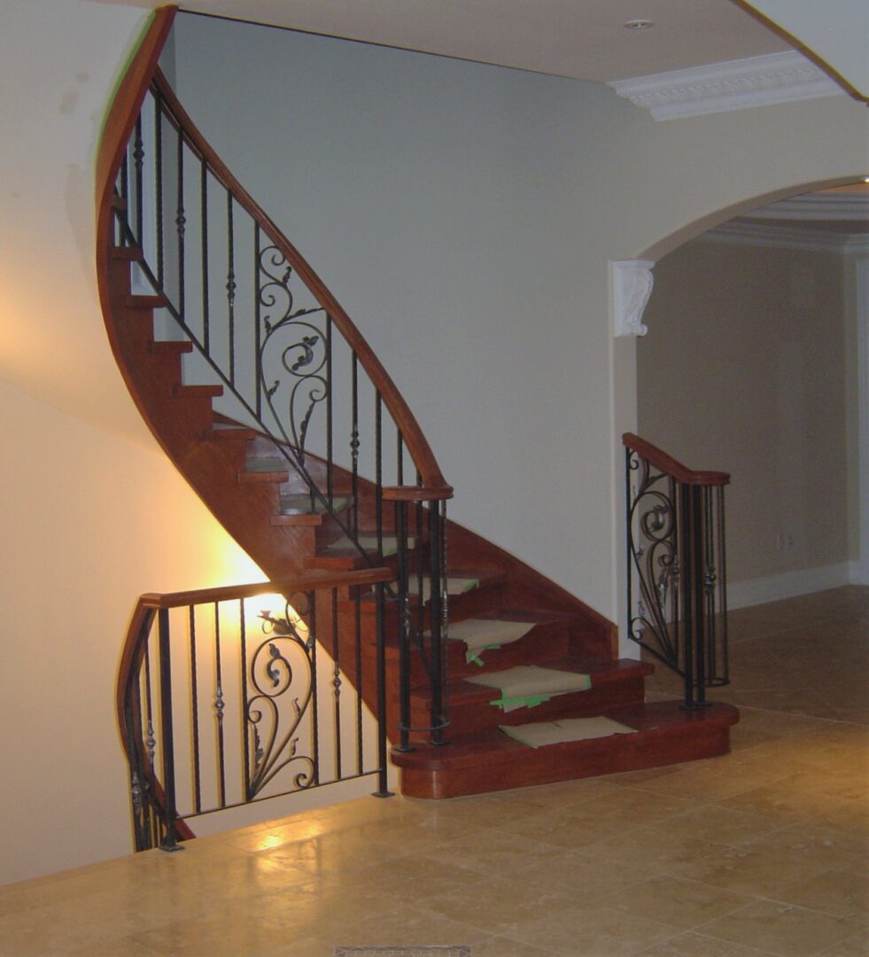 An Iron Pattern Staircase With Wood Railing
