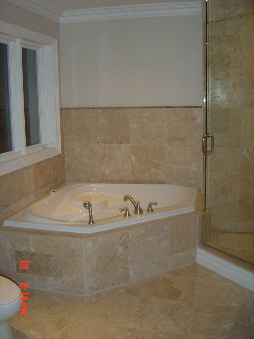 A Corner Tub With Steel Fittings and Marble Bed