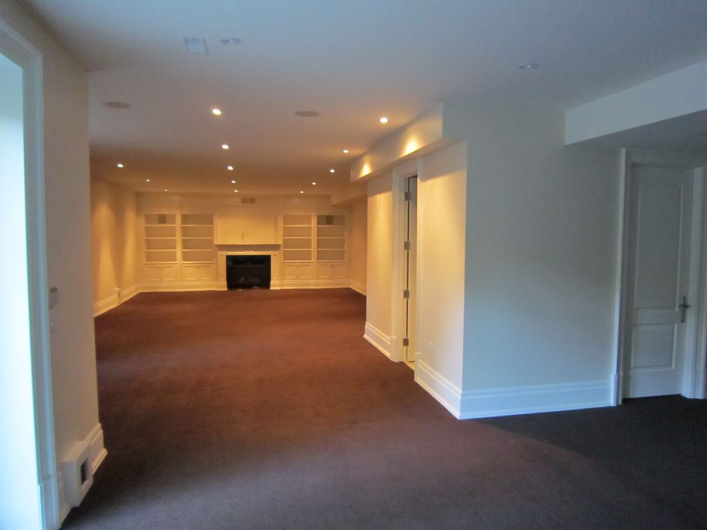 An Empty Room With a Large Cupboards and a Fireplace