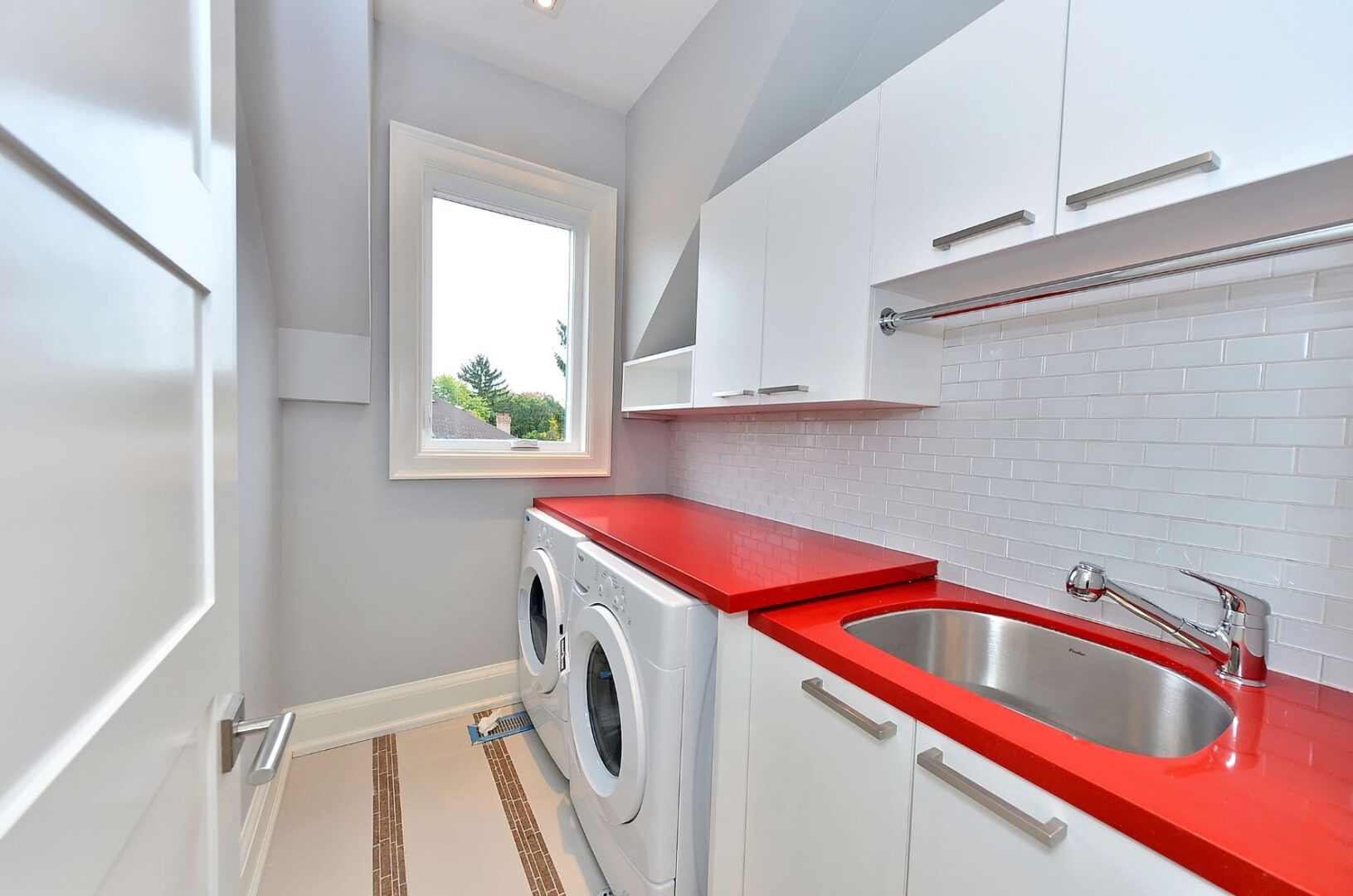 A Laundry Room With a Red Counter Space