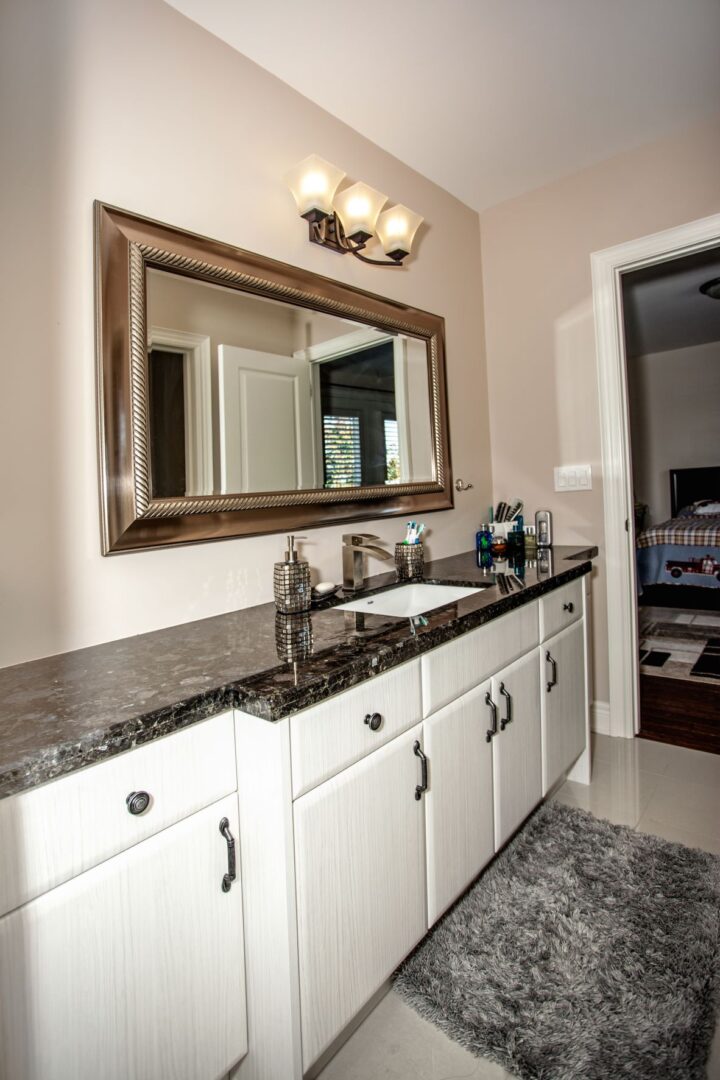 A Bathroom With a White Sink and White Cabinets