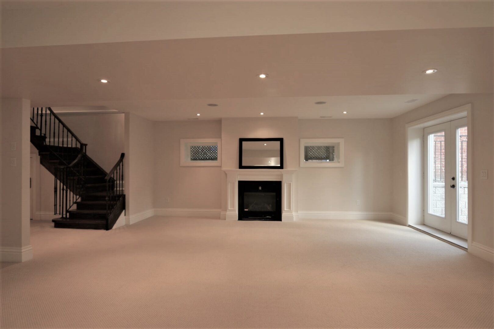 An Empty Room With Dark Staircase and a Fireplace