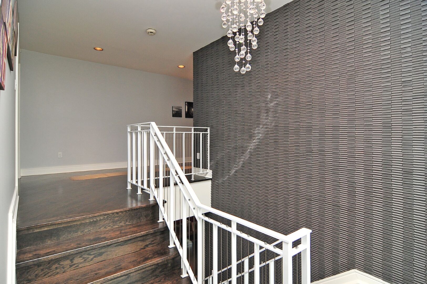 A Grey pattern Wall With a Glass Hanging Light